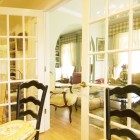 Гостиная прованс, угловой диван, шторы с ламбрекеном, журнальный столик, стеклянные двери, деревянные стулья, фото интерьера гостиной